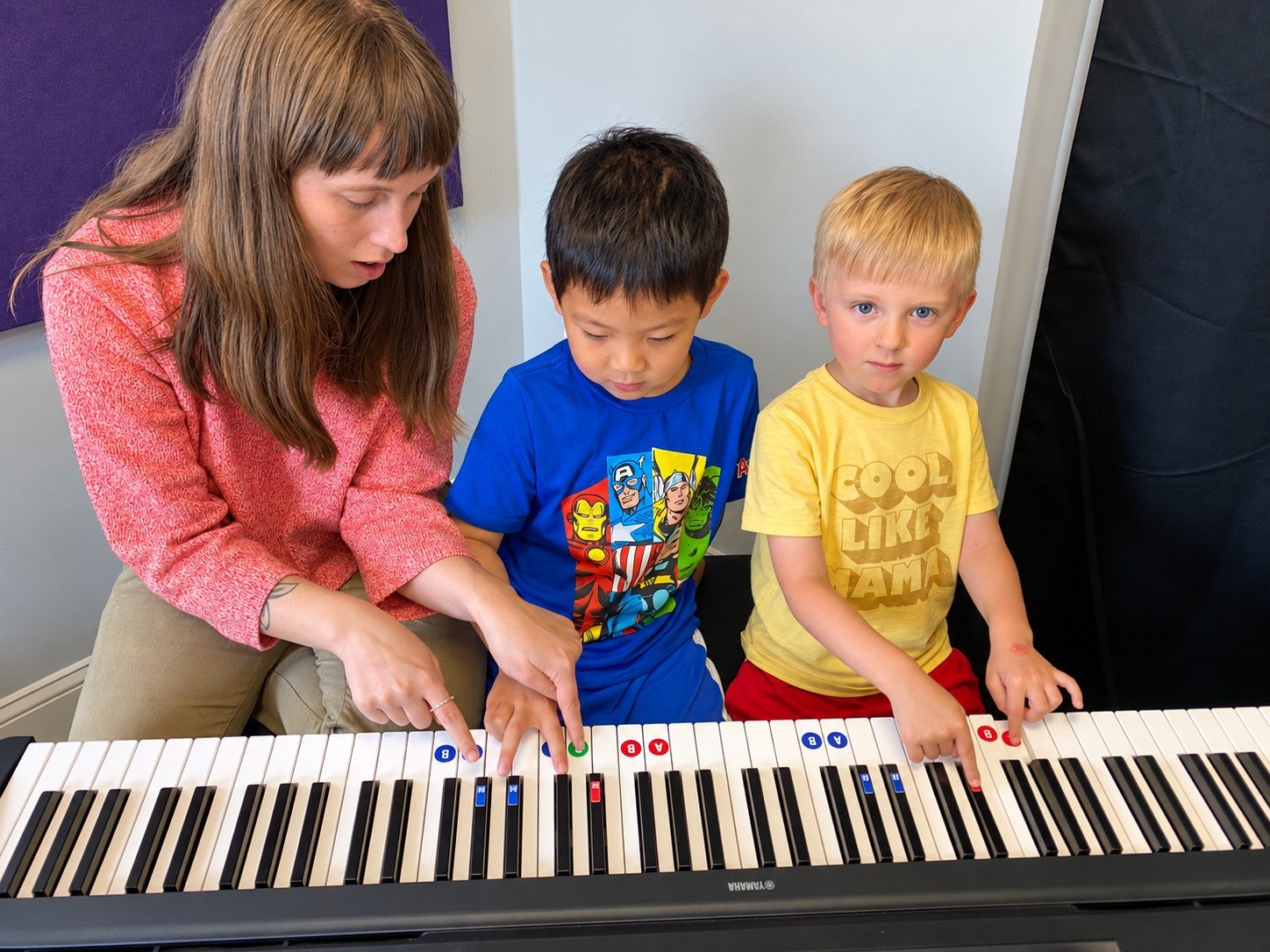 Instructor helping two MiniKeys students explore the piano at Thrive Creative Arts